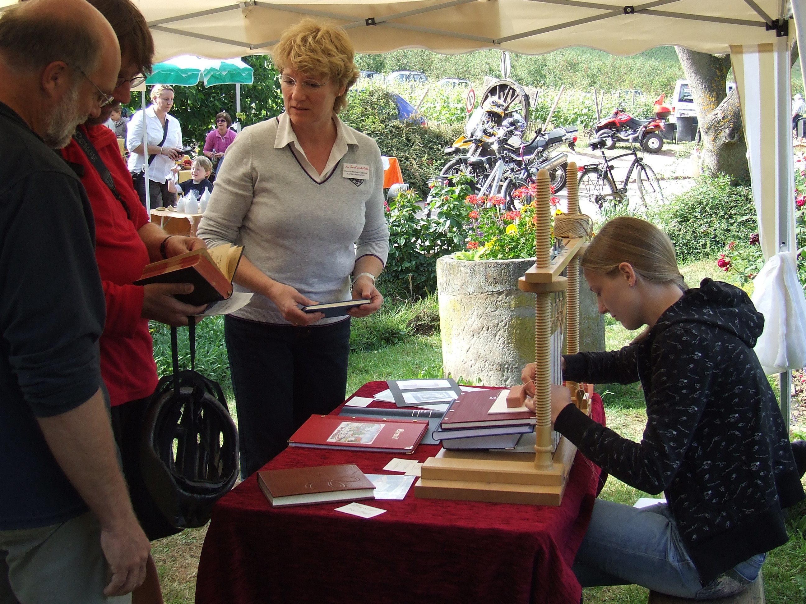 Buchwerkstatt: Beratungsgespräch während einer Ausstellung auf einem Handwerkermarkt